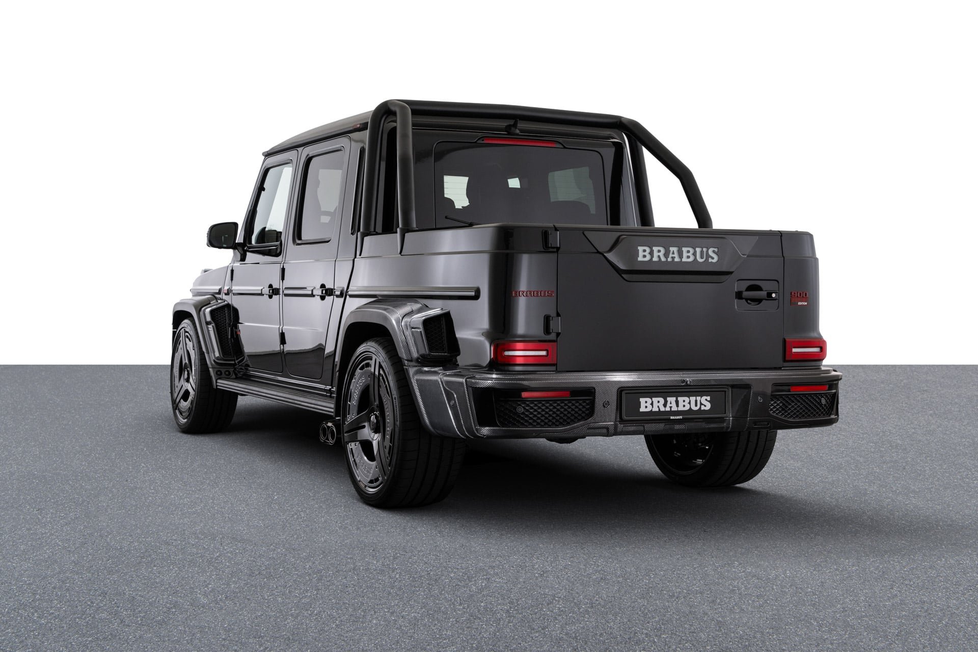Black Brabus P 900 Rocket Edition pickup from the rear three-quarter, showing the roll bar, carbon bed walls and Brabus tailgate