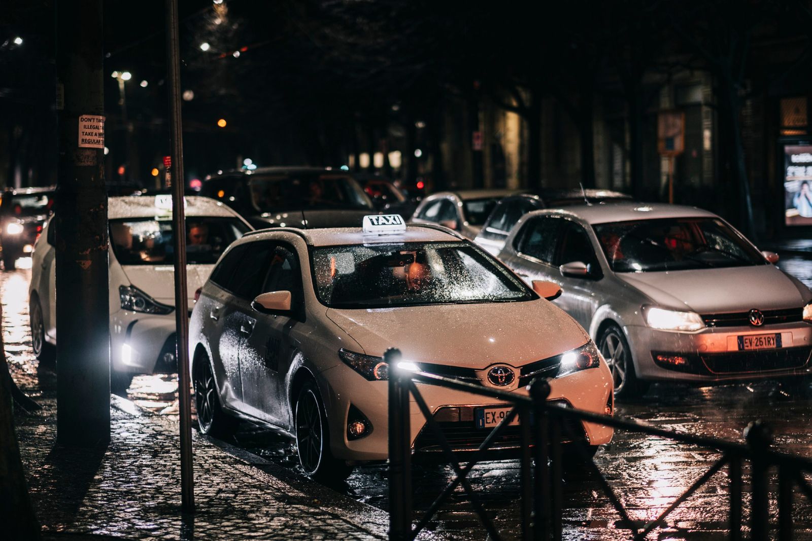 Cars waiting along a wet city street at night