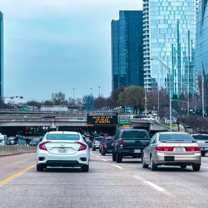 Cars on a Dallas highway with the downtown skyline ahead