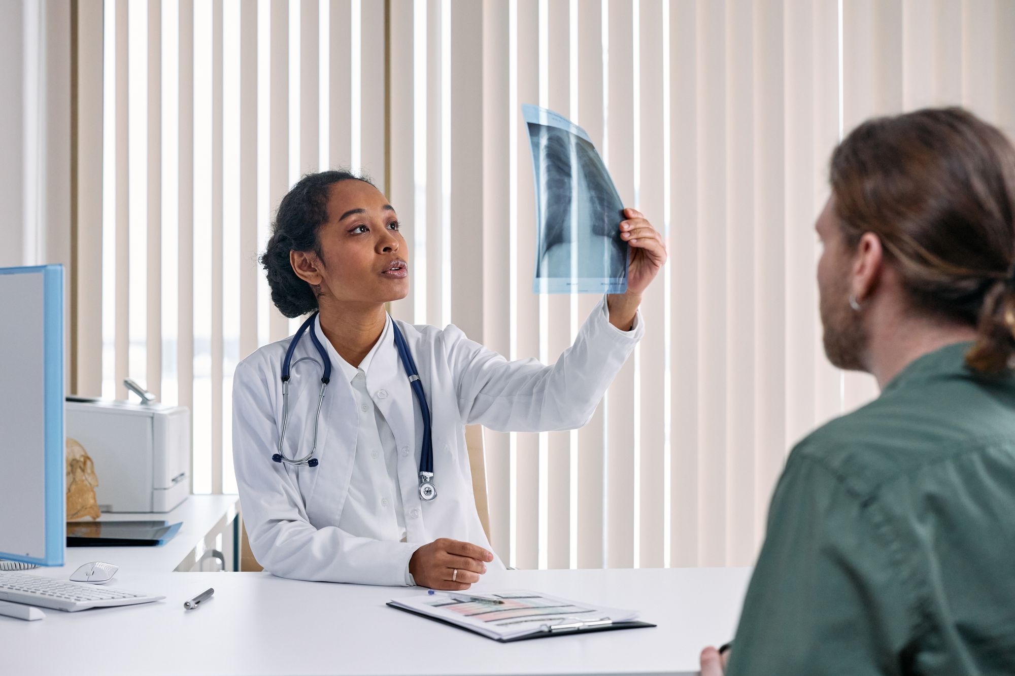 Doctor reviewing an x-ray with a patient in a clinic office