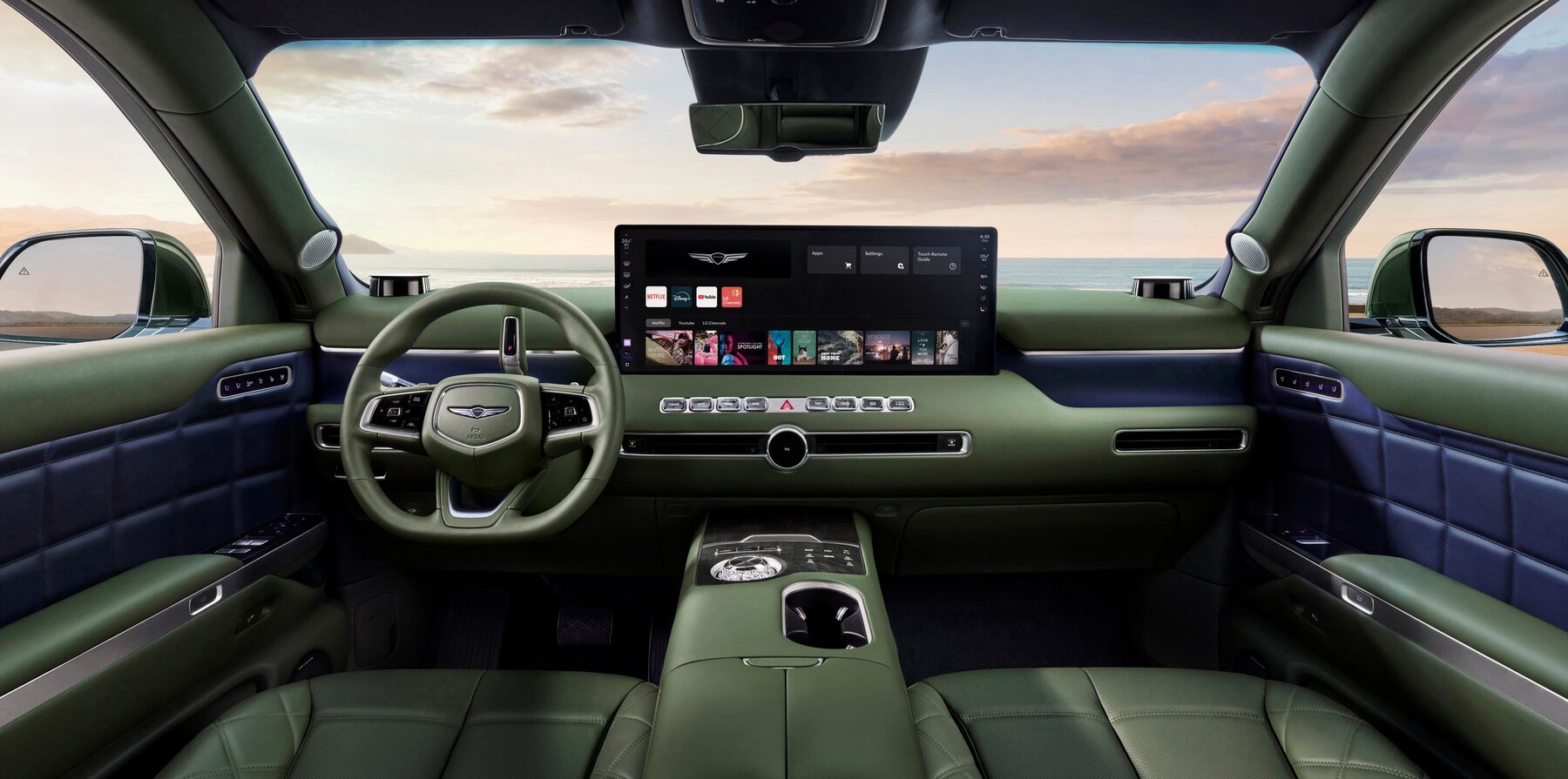 Genesis GV90 dashboard in green leather with a wide central OLED display and a two-spoke steering wheel