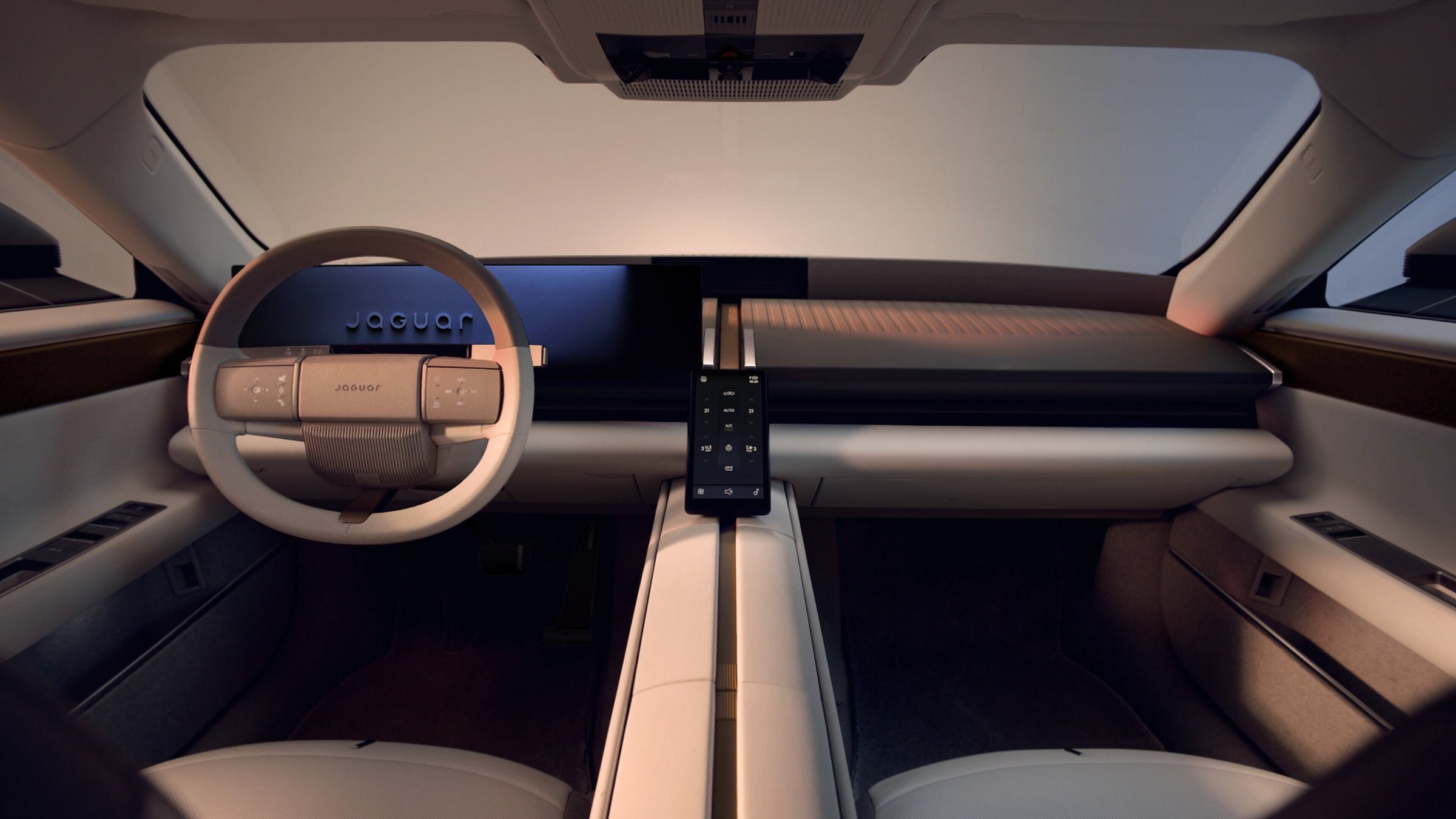 Jaguar Type 01 front cabin with a round-rimmed steering wheel, wide dashboard display and a central spine between the seats