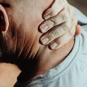 Man holding the back of his neck in pain