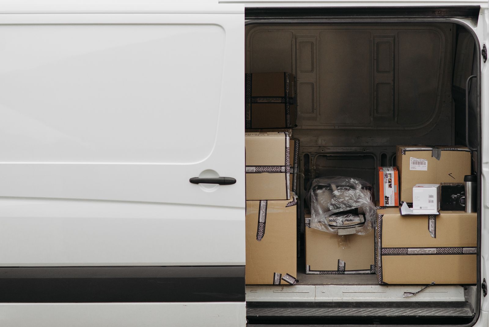 White cargo van with its side door open and packages inside