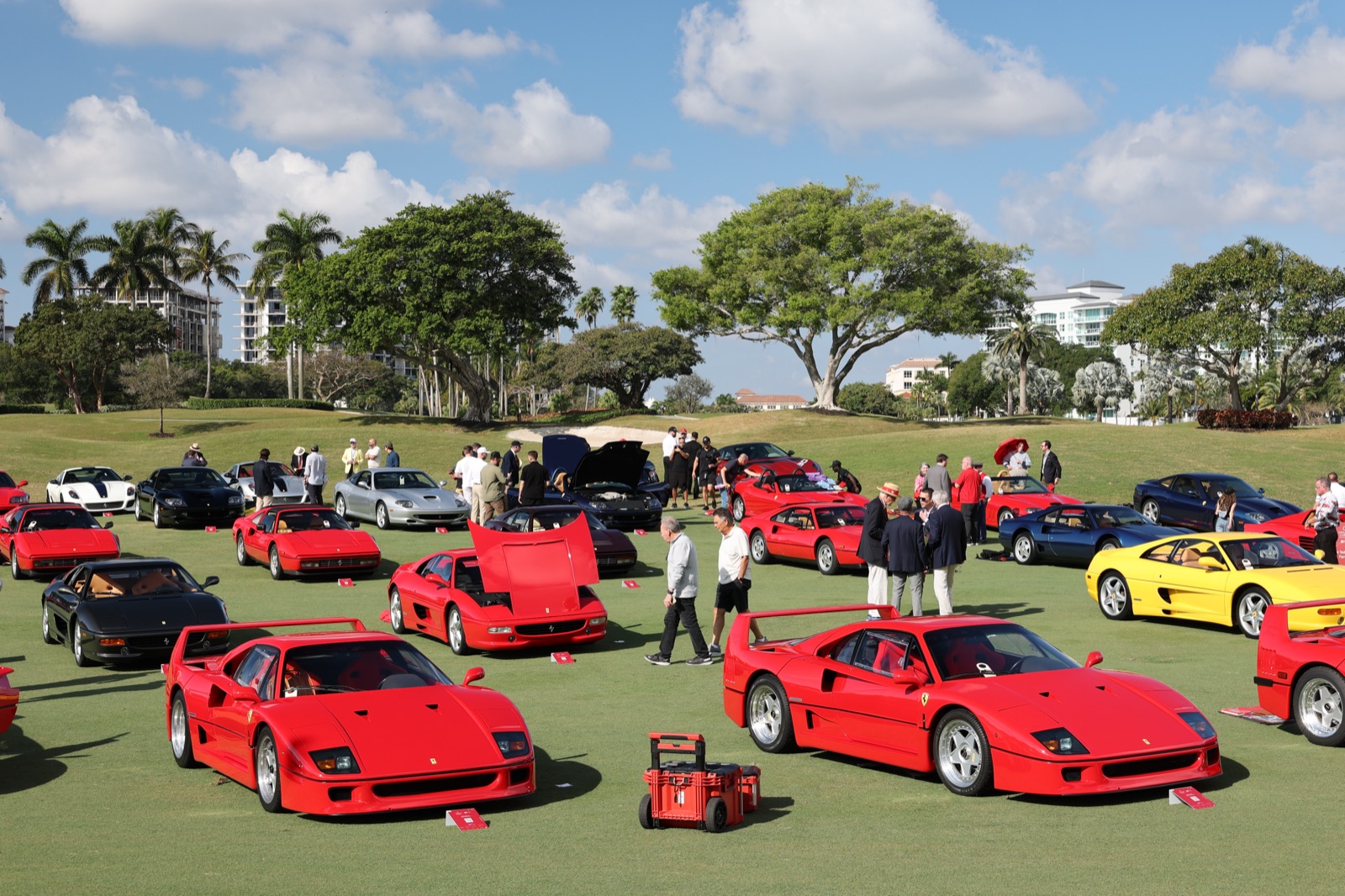 Two red Ferrari F40s parked on the lawn at the 2026 Palm Beach Cavallino Classic with F355s, a Testarossa and a 360 behind them