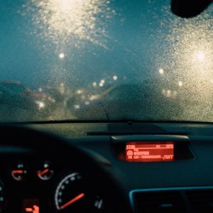 Rain on a car windshield at night with the dashboard gauges lit