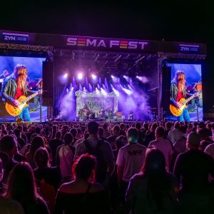 A crowd watches a band on the SEMA Fest main stage at night in Las Vegas