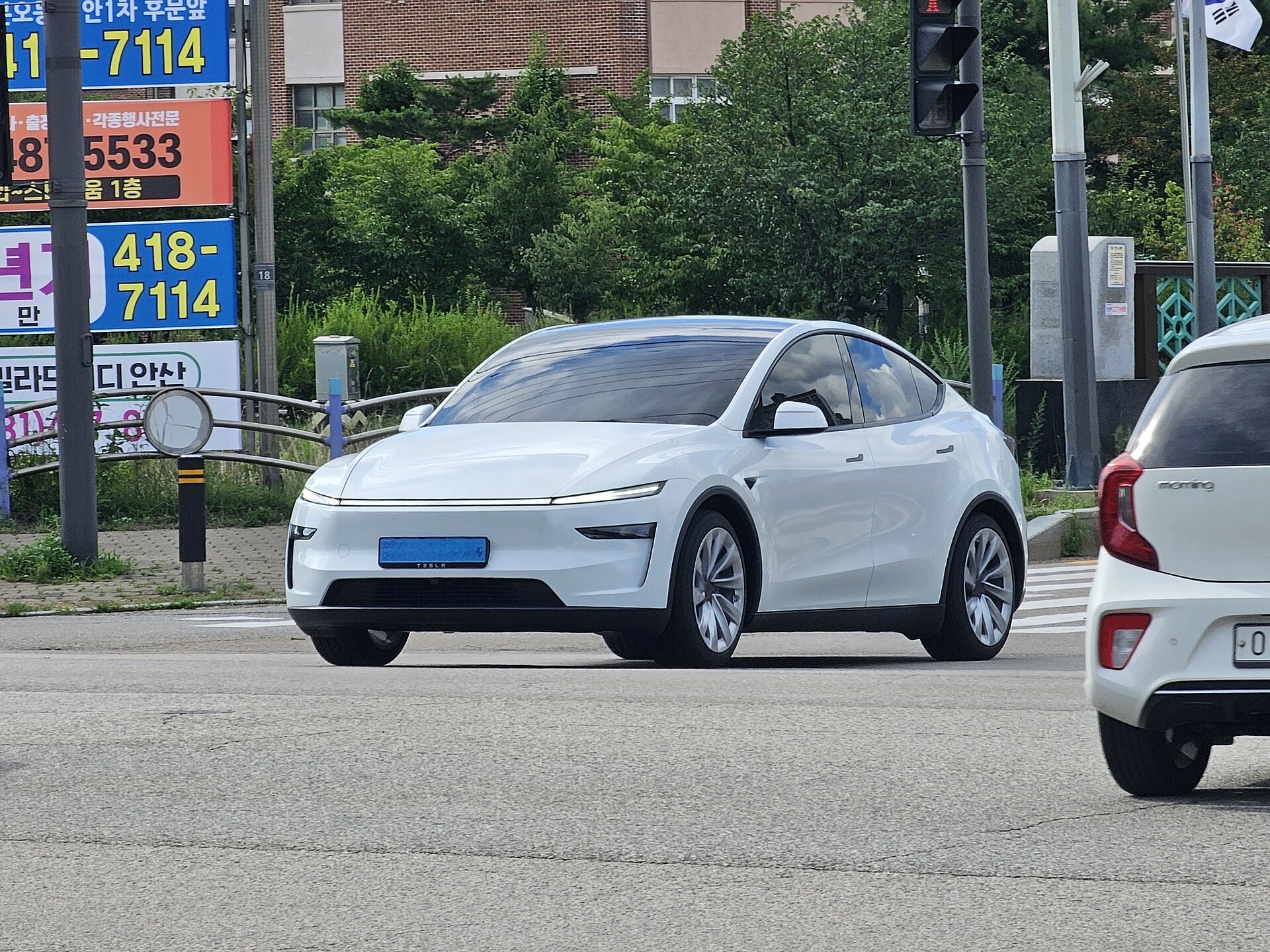 White Tesla Model Y crossing an intersection in South Korea