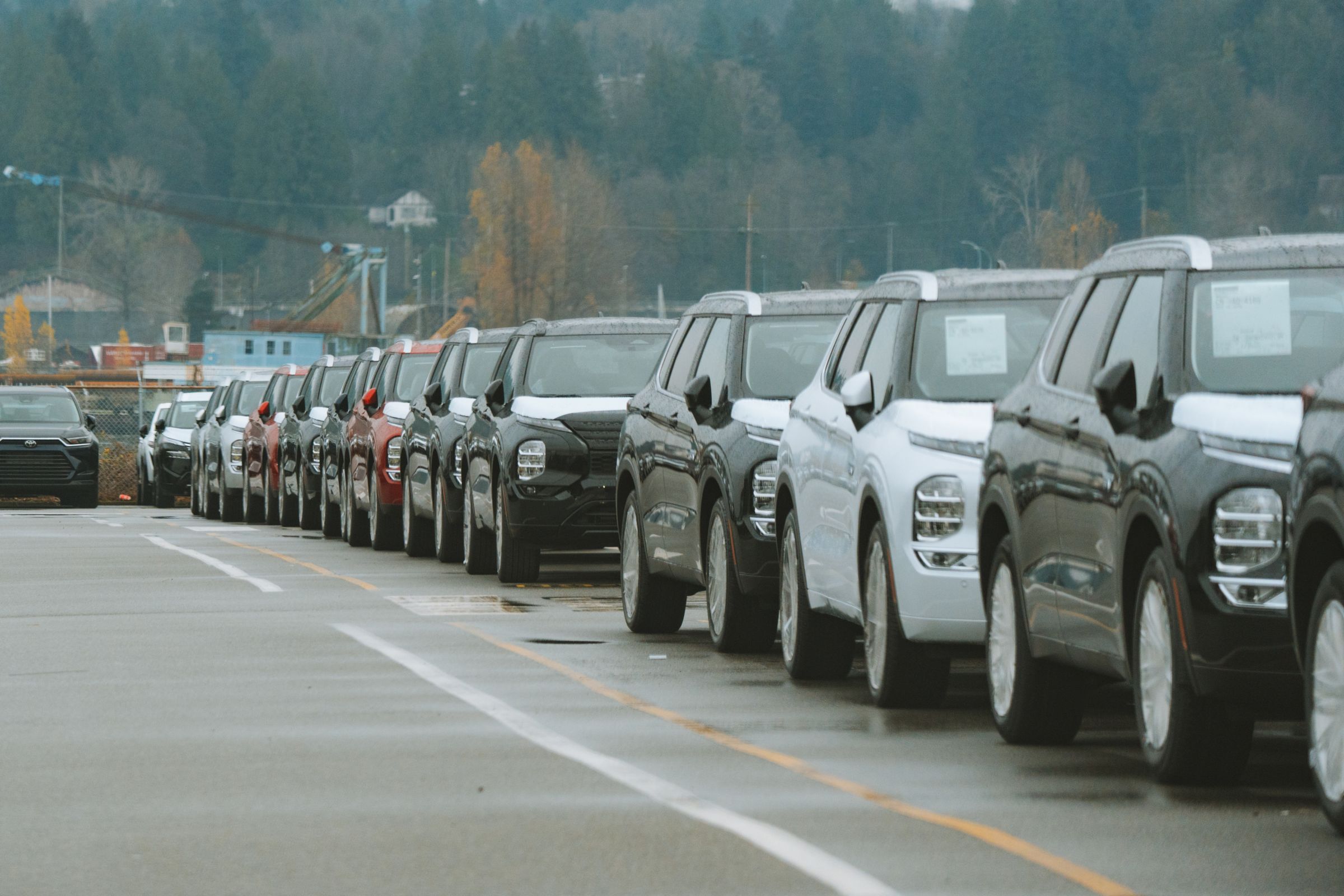 Row of new SUVs with window stickers parked on a dealership lot