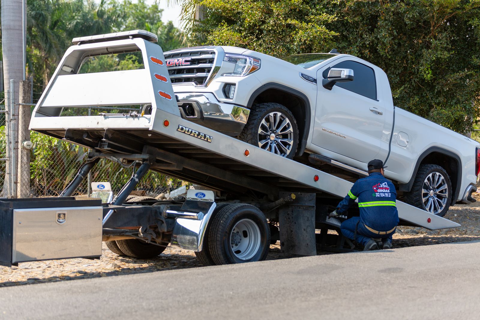A Serious Car Wreck Can Trigger Hidden Costs for Injured Drivers 2 Flatbed tow truck loading a white pickup truck