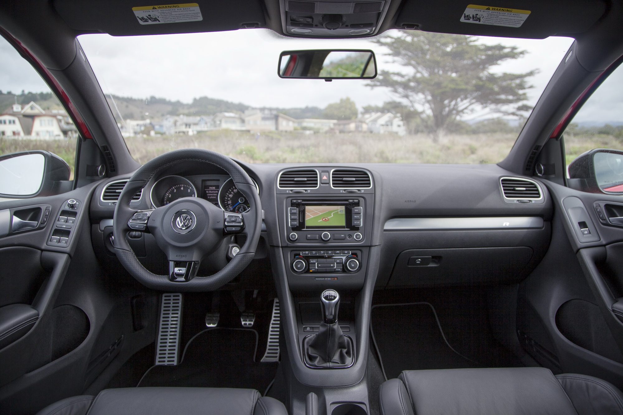 Dashboard of the Volkswagen Golf R with the flat-bottom R steering wheel, navigation screen and six-speed manual shifter
