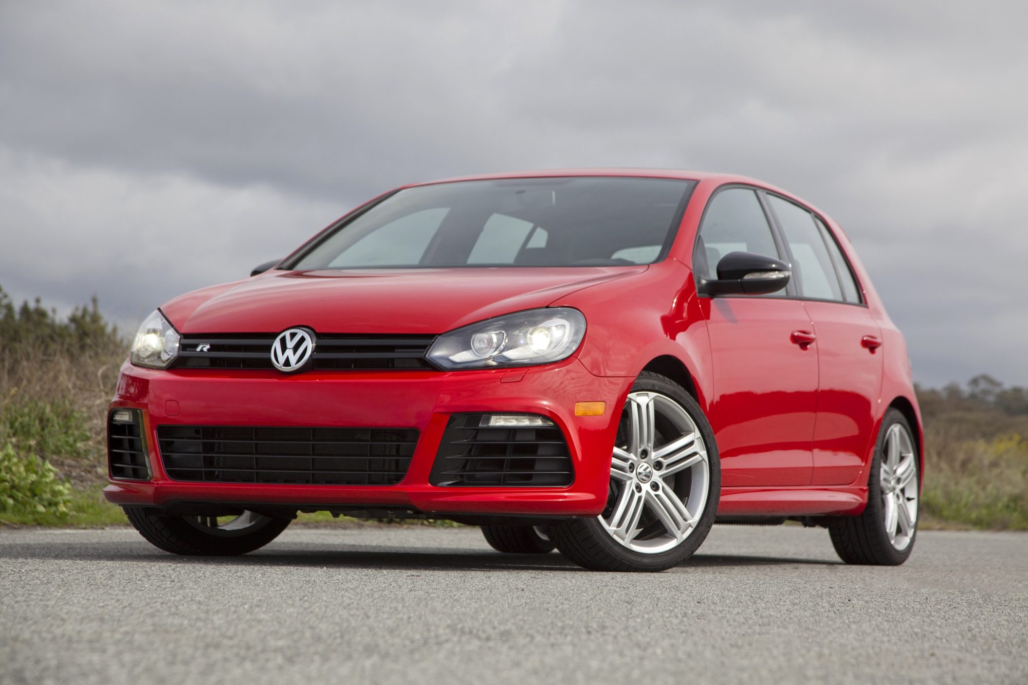 Front three-quarter view of a red four-door Volkswagen Golf R with its R grille badge and 18-inch wheels