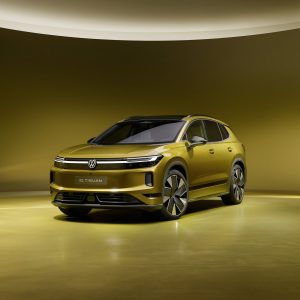 Volkswagen ID. Tiguan in Olive Bronze metallic, front three-quarter view in a gold-lit studio